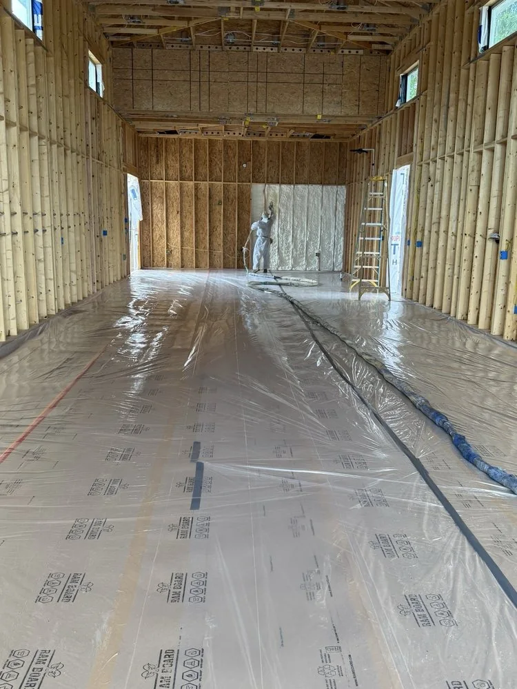 Spray foam insulation project in progress around framed cavities
